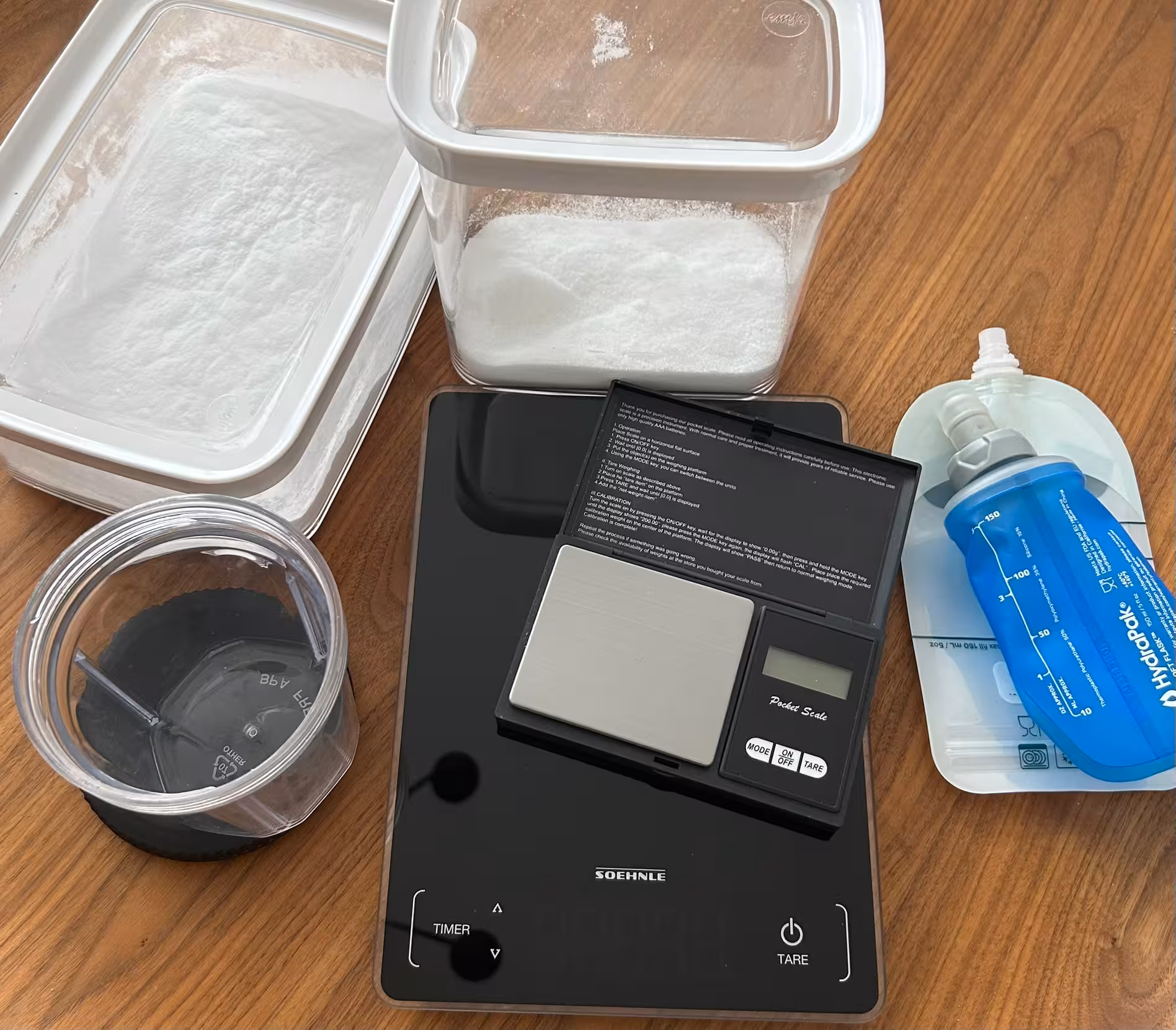 Image of scale, powder, hydra flasks, and reusable squeeze pouches